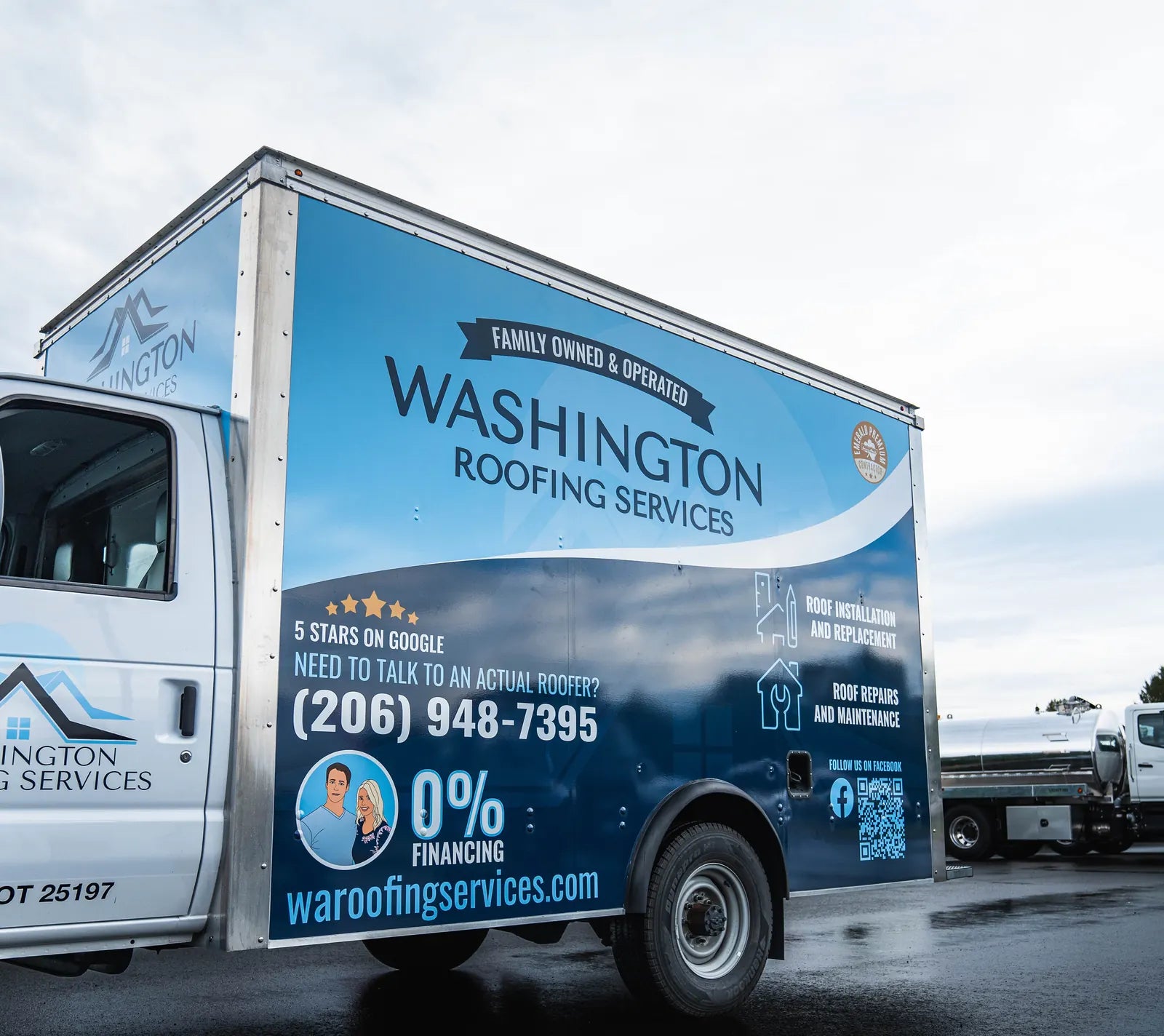 Side of a box truck wrapped in blue graphics for a roofing company showing a 5-star rating, phone number and website