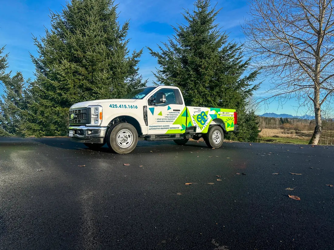 White Ford Super Duty pickup with a lime green and blue partial wrap for an auto equipment distributor, by Ardor Printing