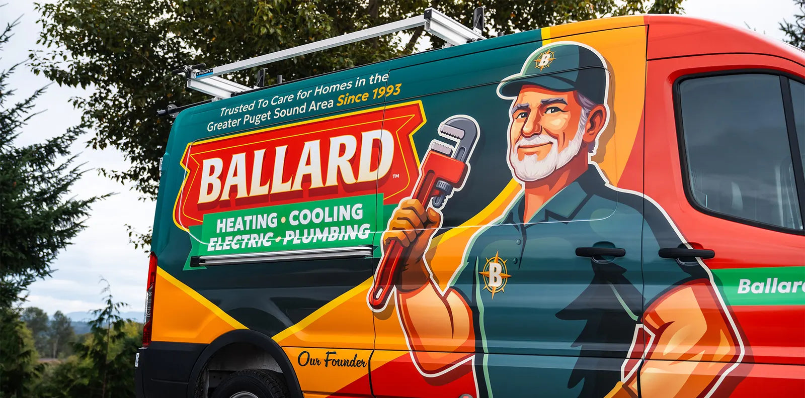 Rear three-quarter view of a Ford Transit with a full service-company wrap and a plumber mascot
